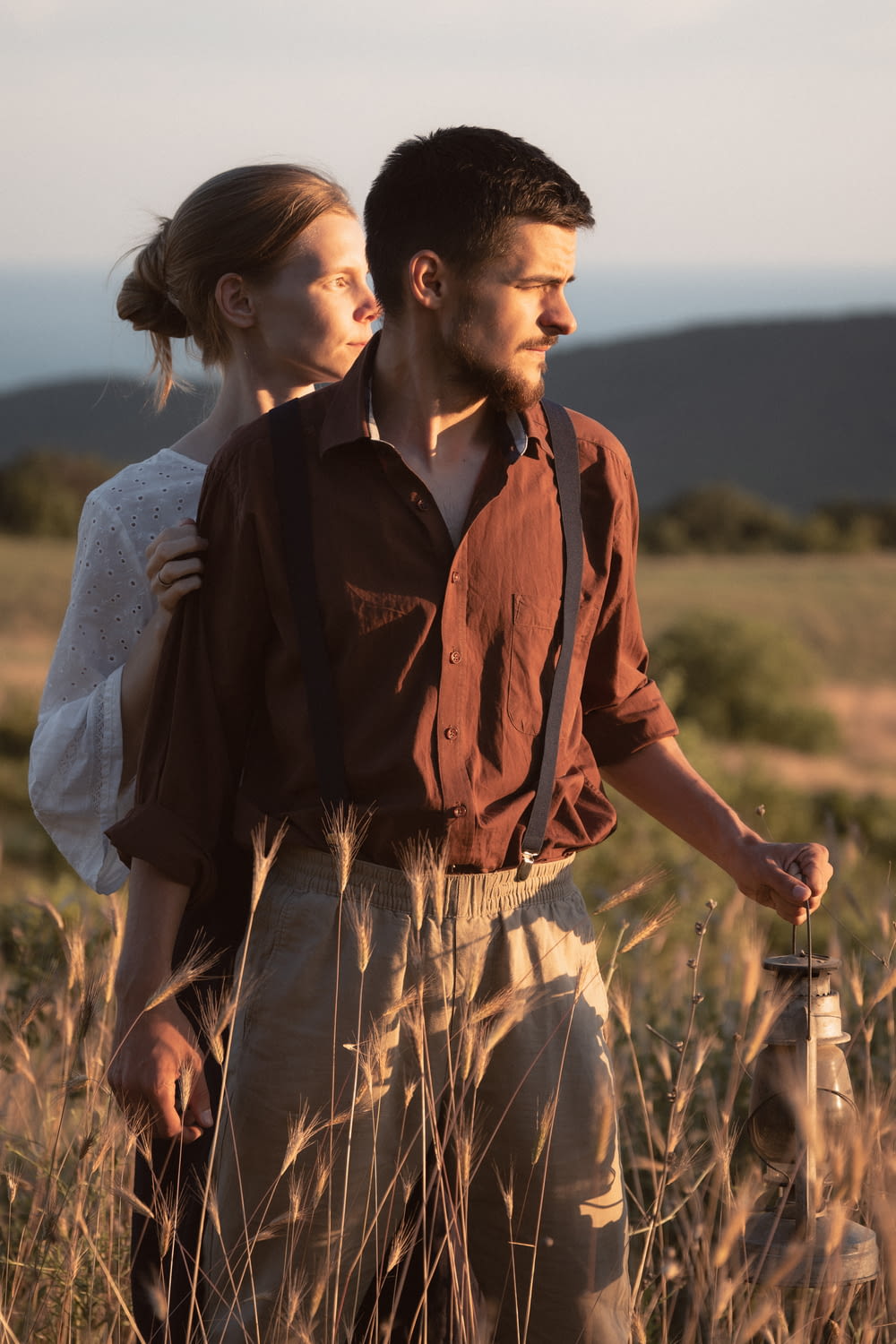 a man and woman standing in a field