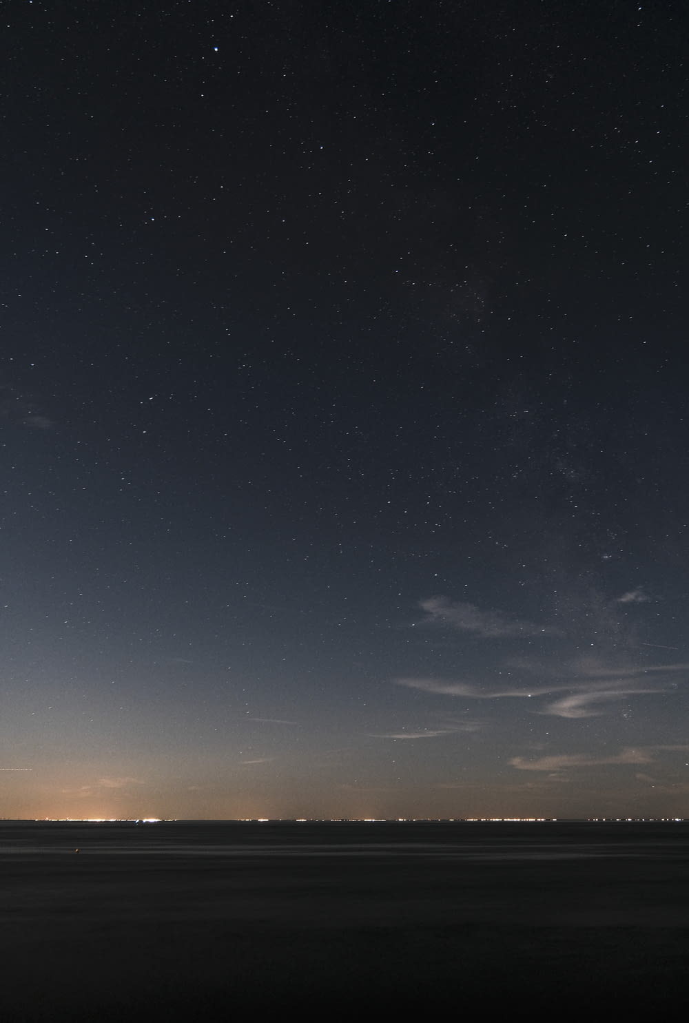 a starry night sky over a beach