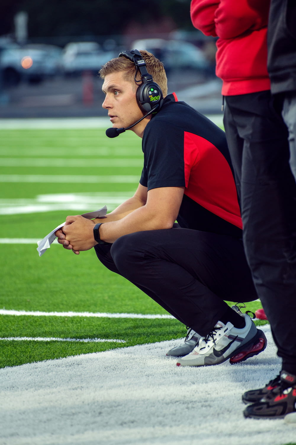 a person wearing headphones and kneeling on a football field