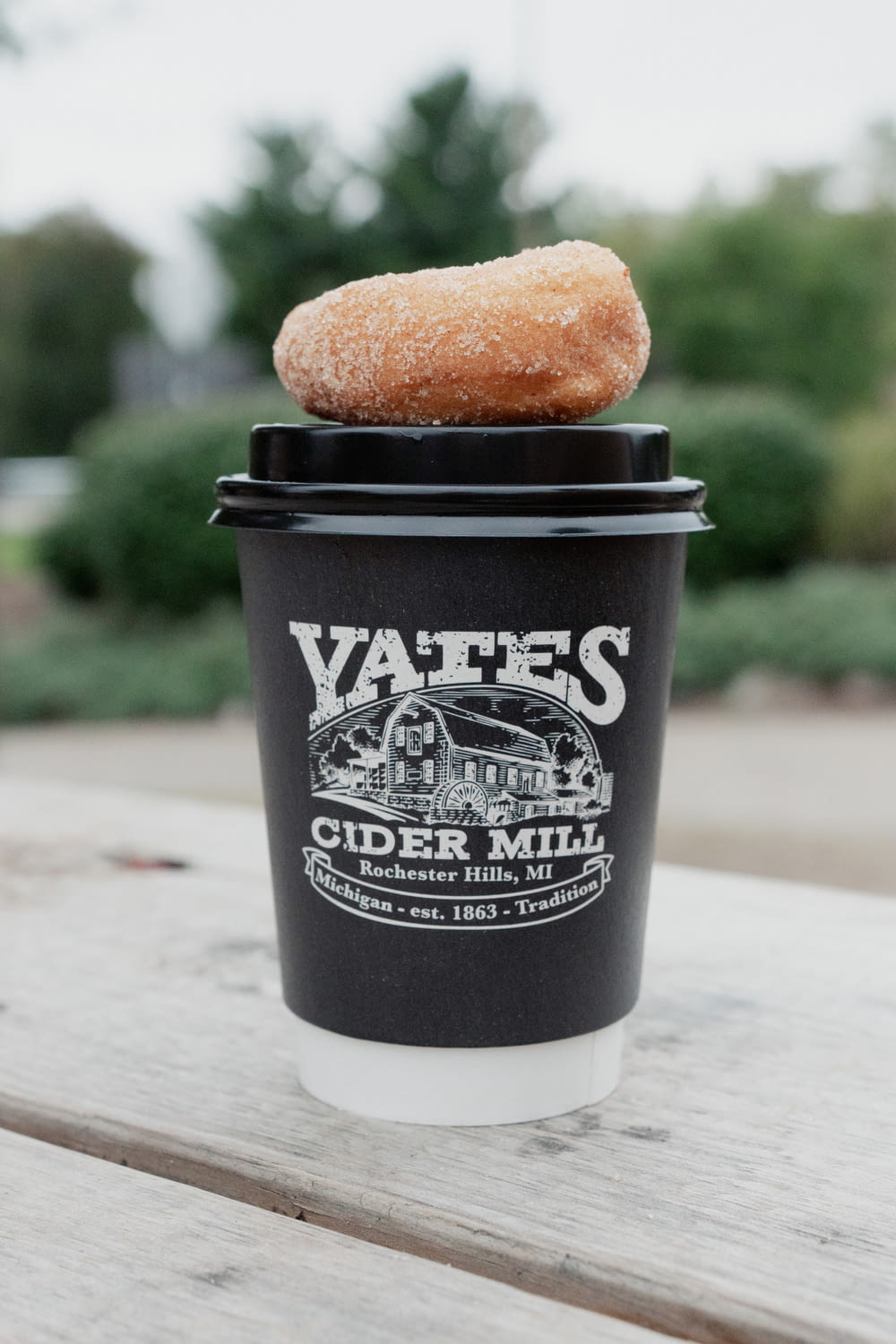 a cup of coffee with a donut on top