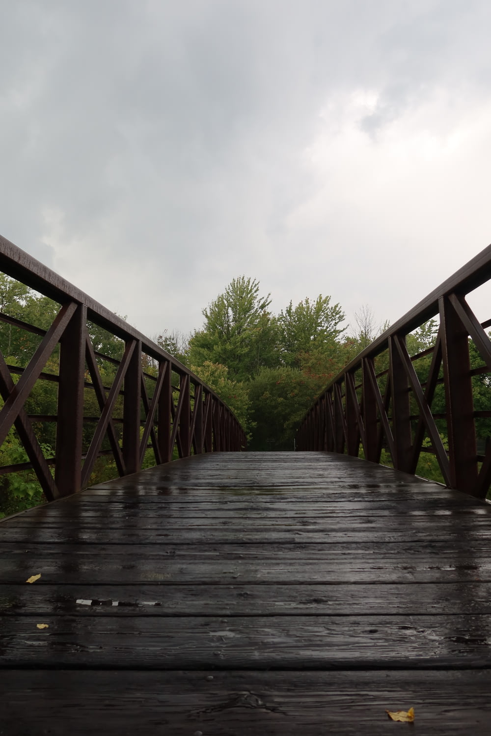 a wooden bridge with trees in the background