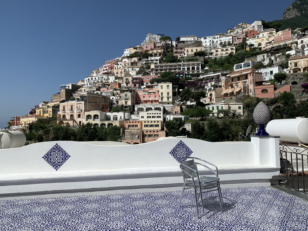 a white wall with a chair and a city in the background