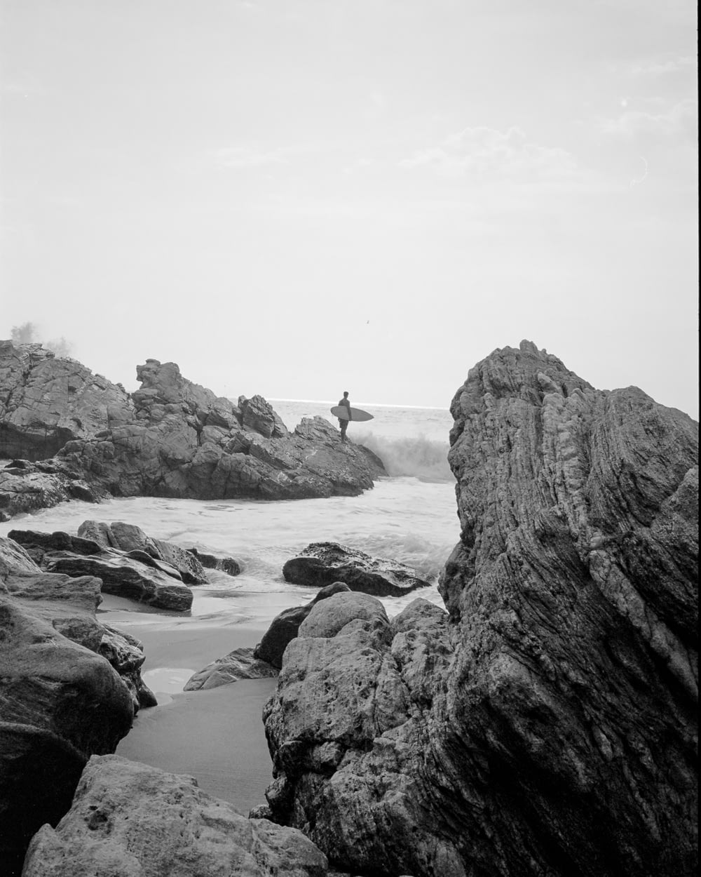 una persona seduta su una roccia nell'acqua