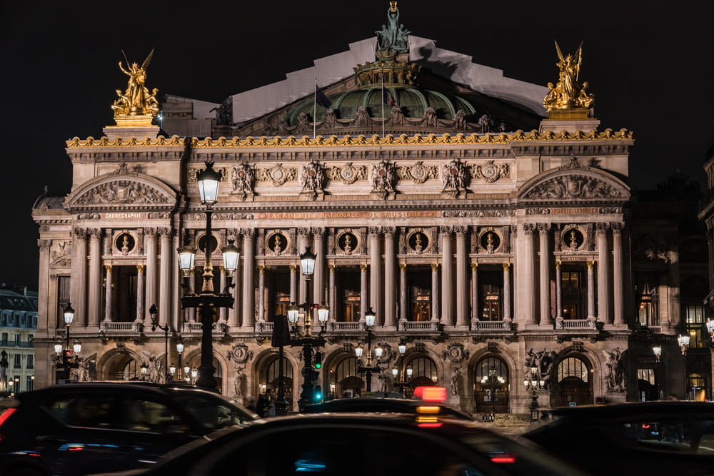a large building with columns and statues with Palais Garnier in the background