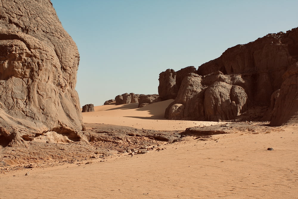 a sandy beach with large rocks