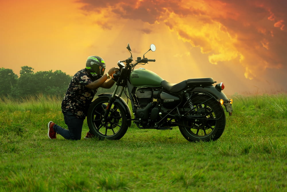 a person kneeling next to a motorcycle