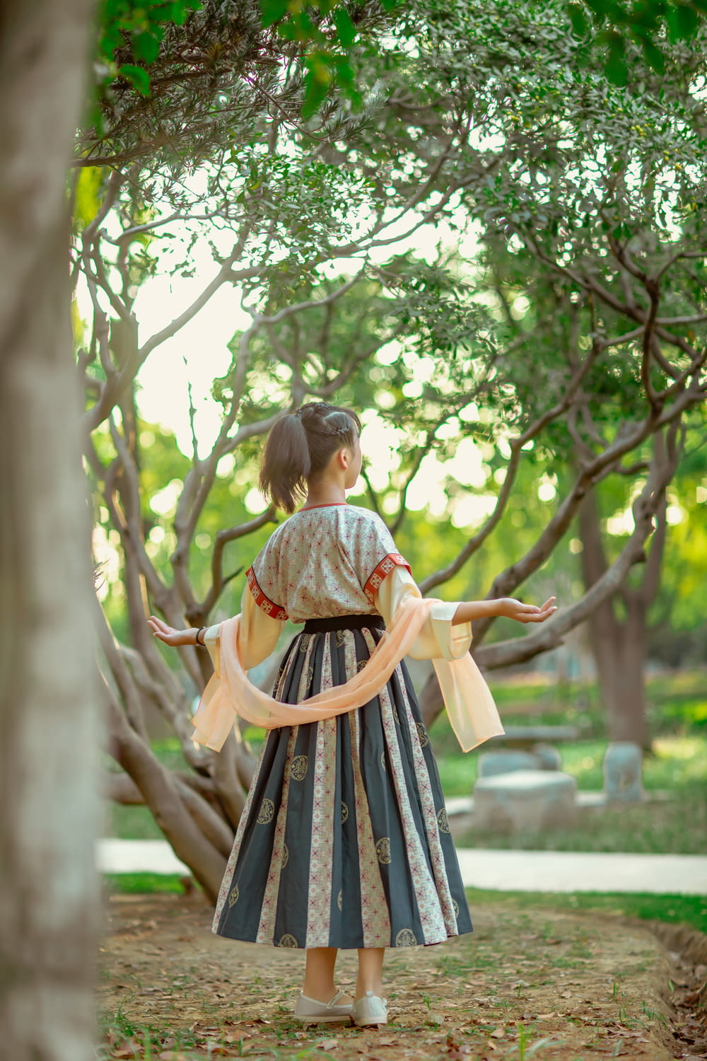 a person in a dress holding a tree branch