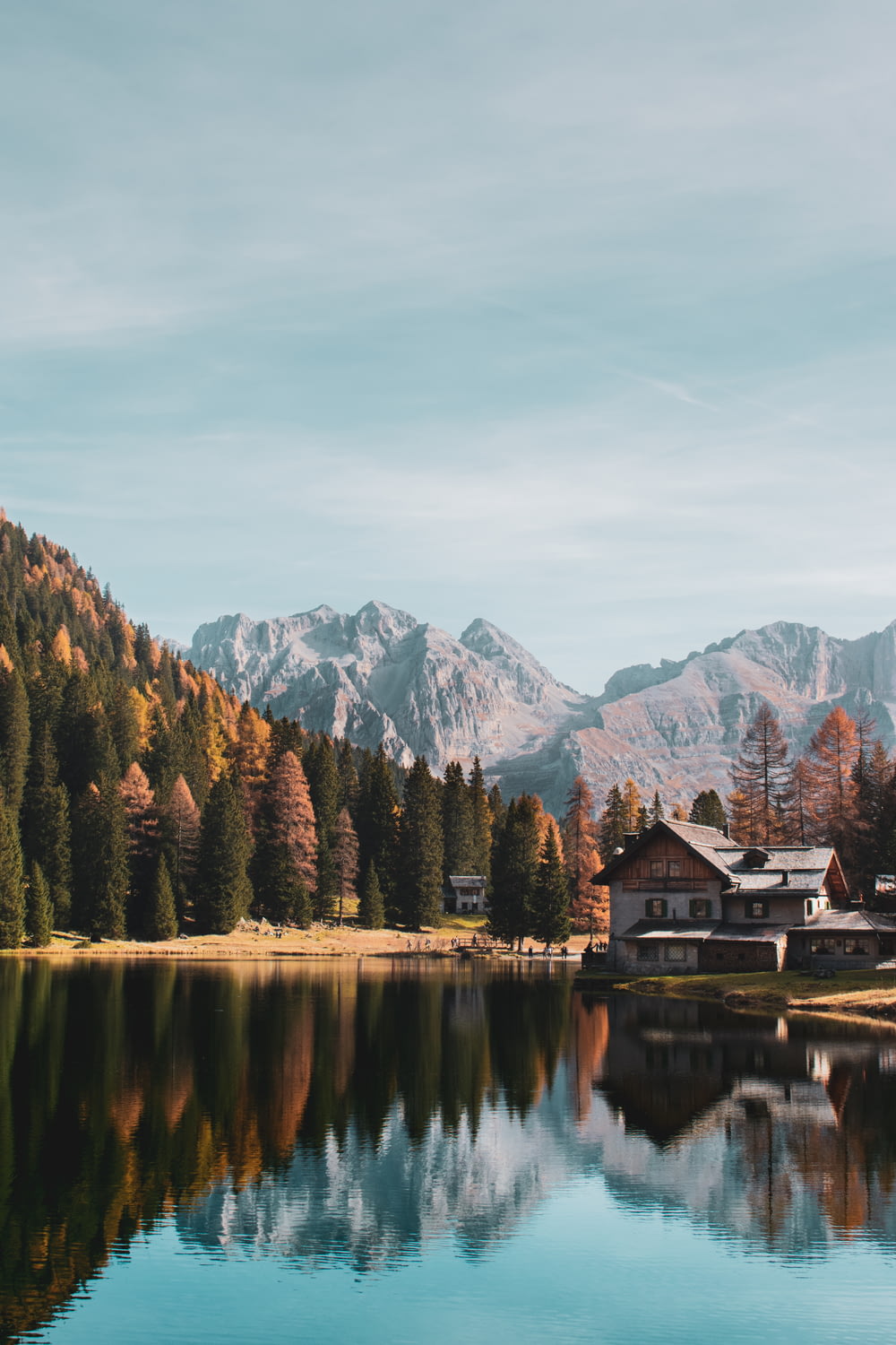 a house by a lake with mountains in the background