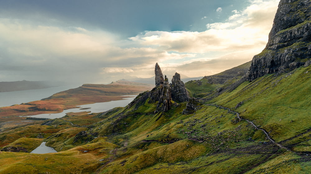 a rocky mountain with a valley below with The Storr in the background