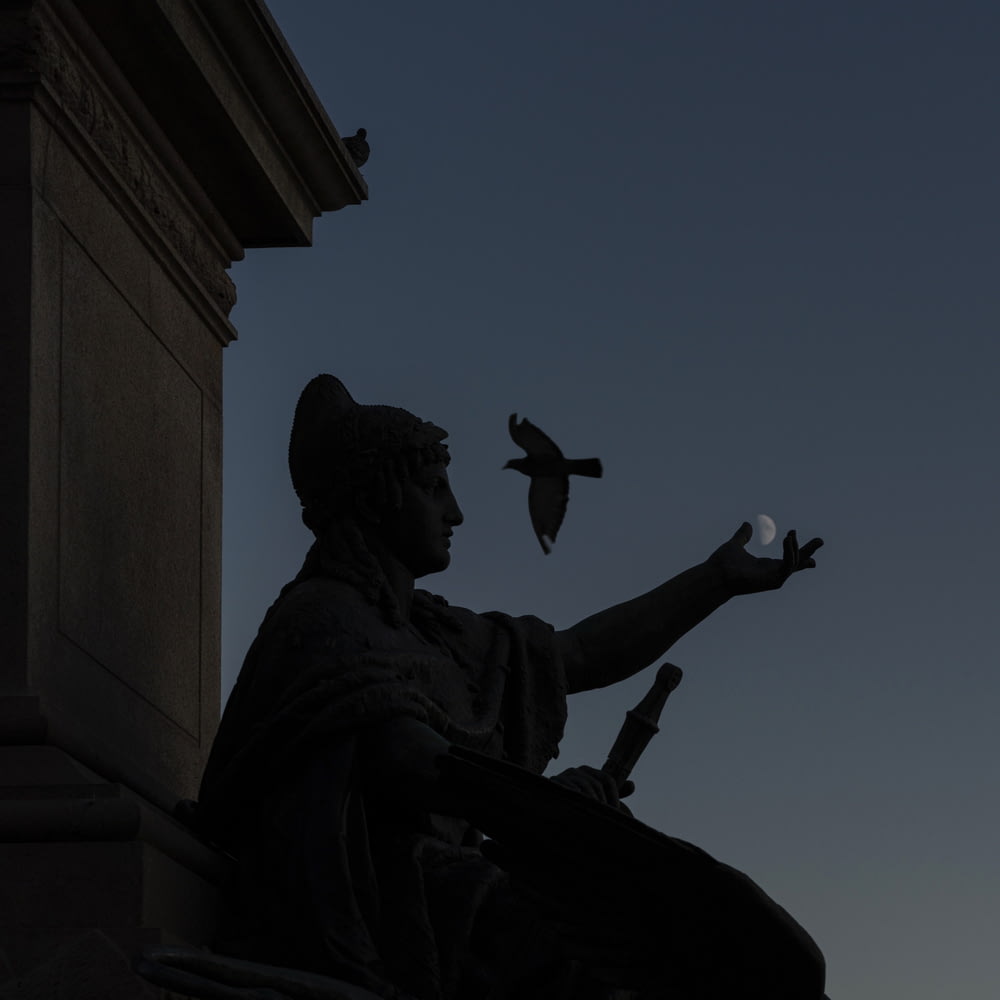 a statue of a person holding a bird