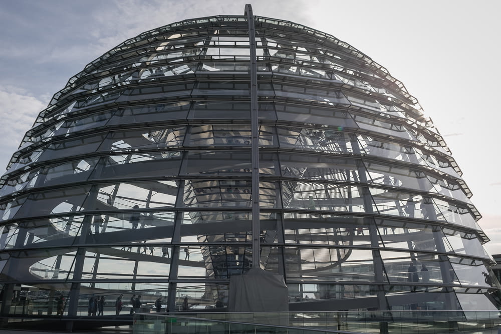 a large glass building with Reichstag dome in the background
