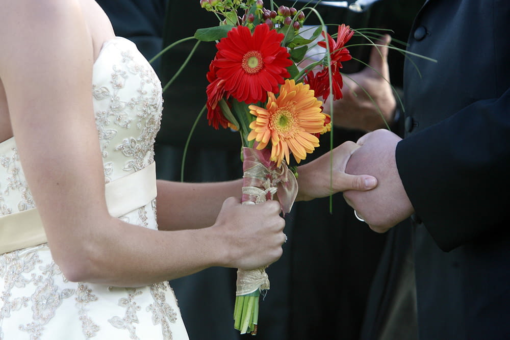 a bride and groom holding flowers