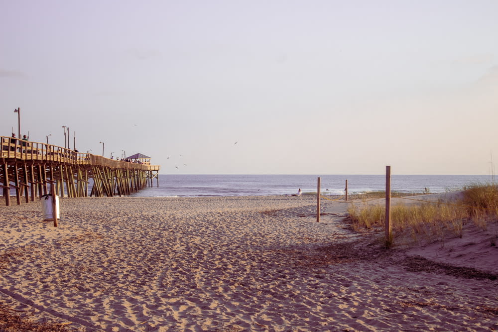 a sandy beach with a pier