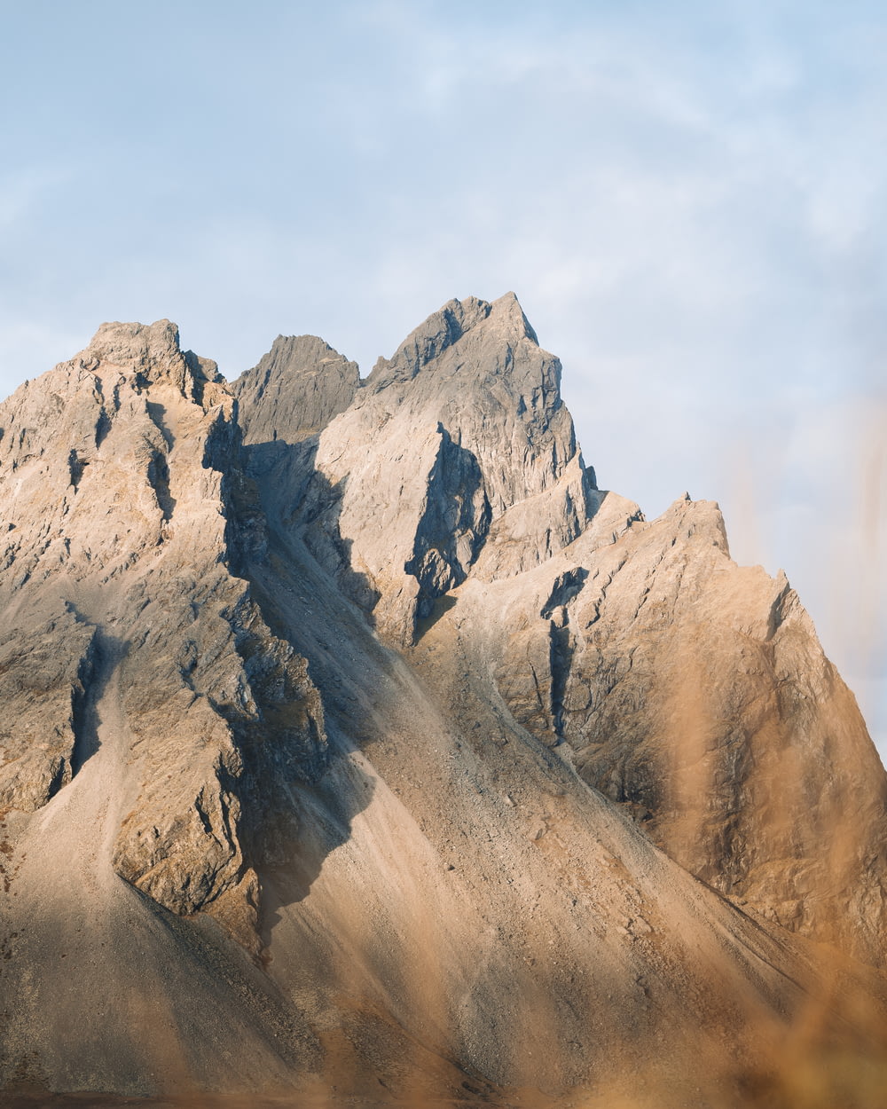 a rocky mountain with a blue sky