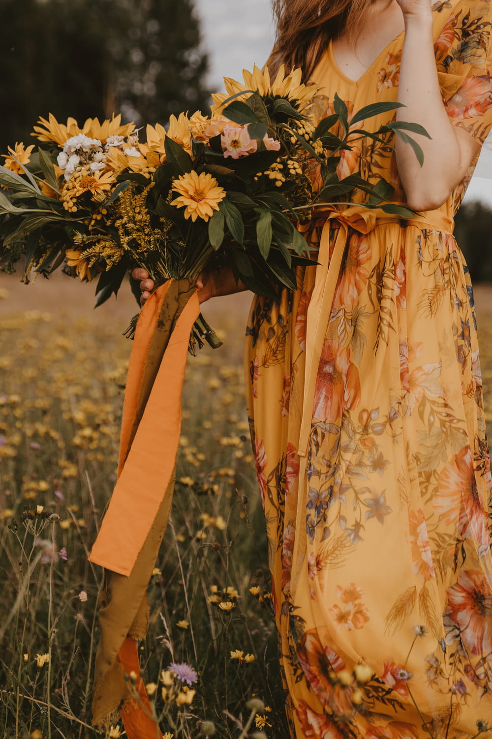 a person wearing a yellow dress with flowers on it