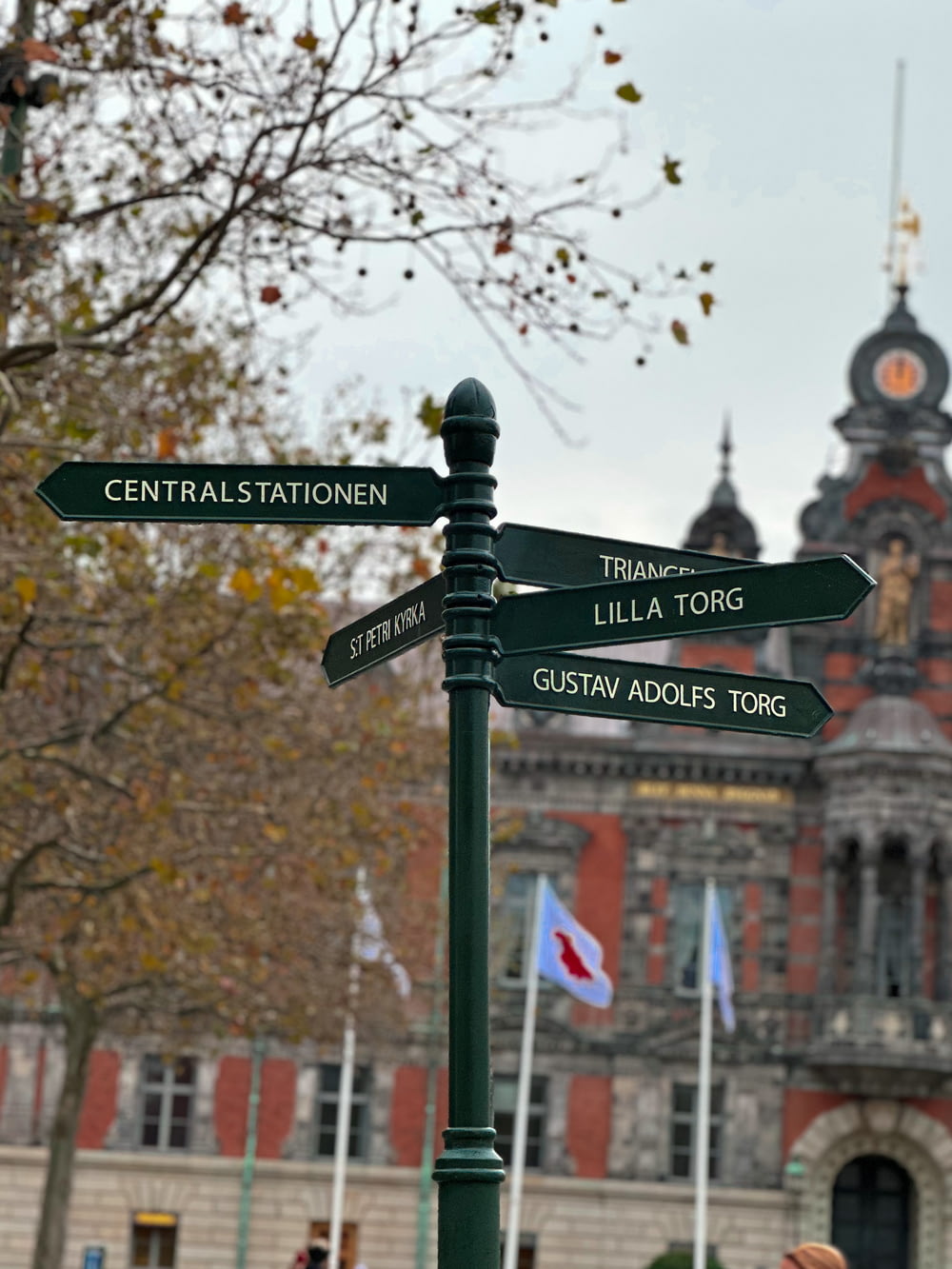 a street sign with a clock tower in the background