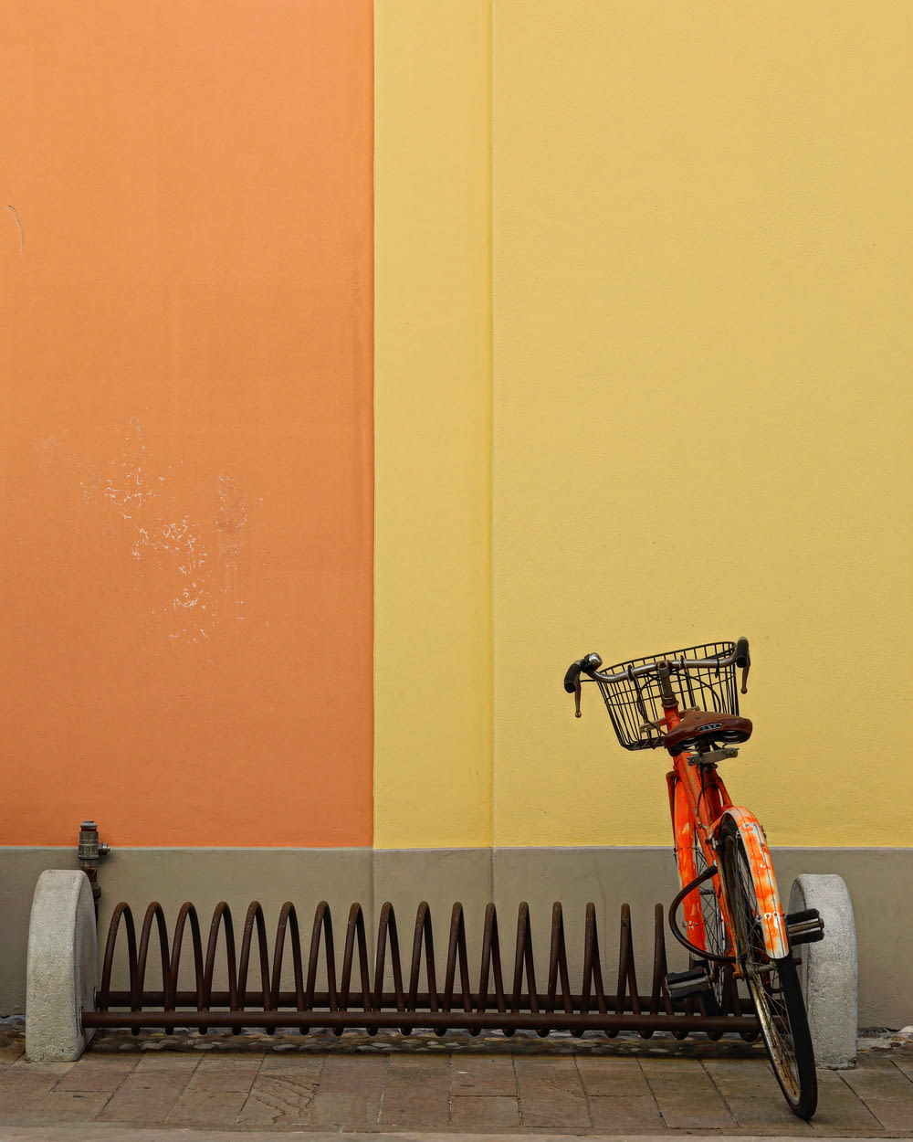 a bicycle parked next to a wall