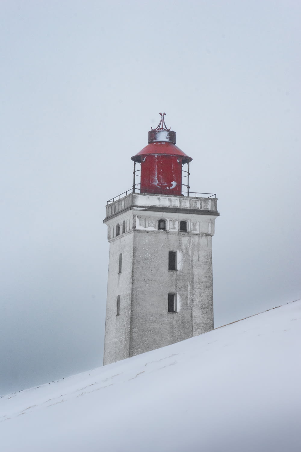 a lighthouse on a snowy hill