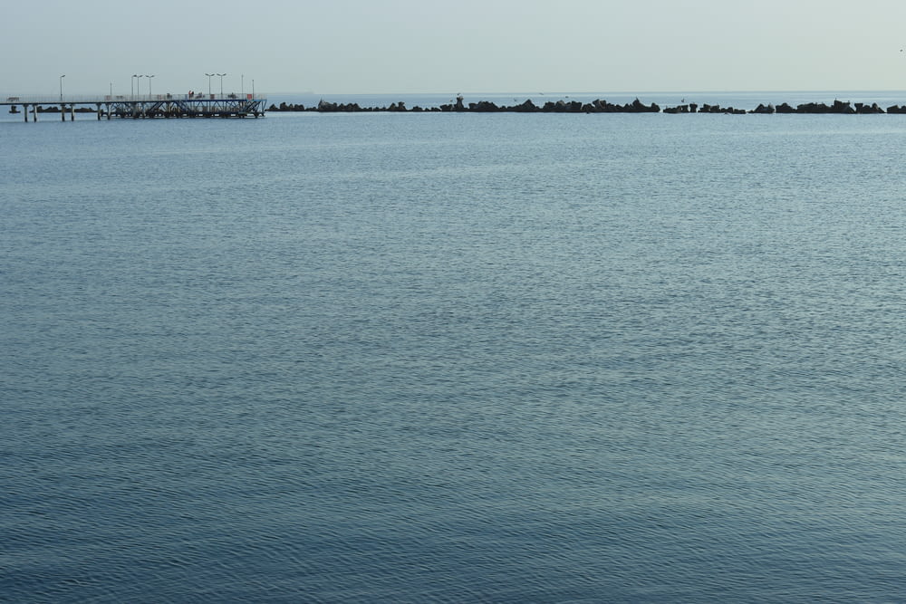 a body of water with a dock and a pier in the distance
