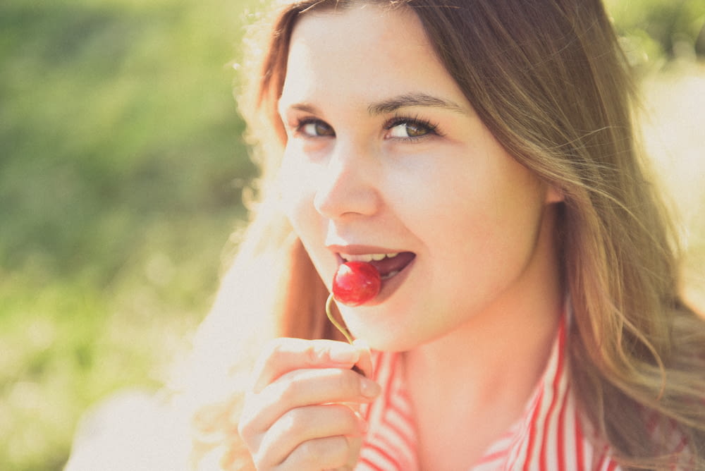 a woman eating a strawberry