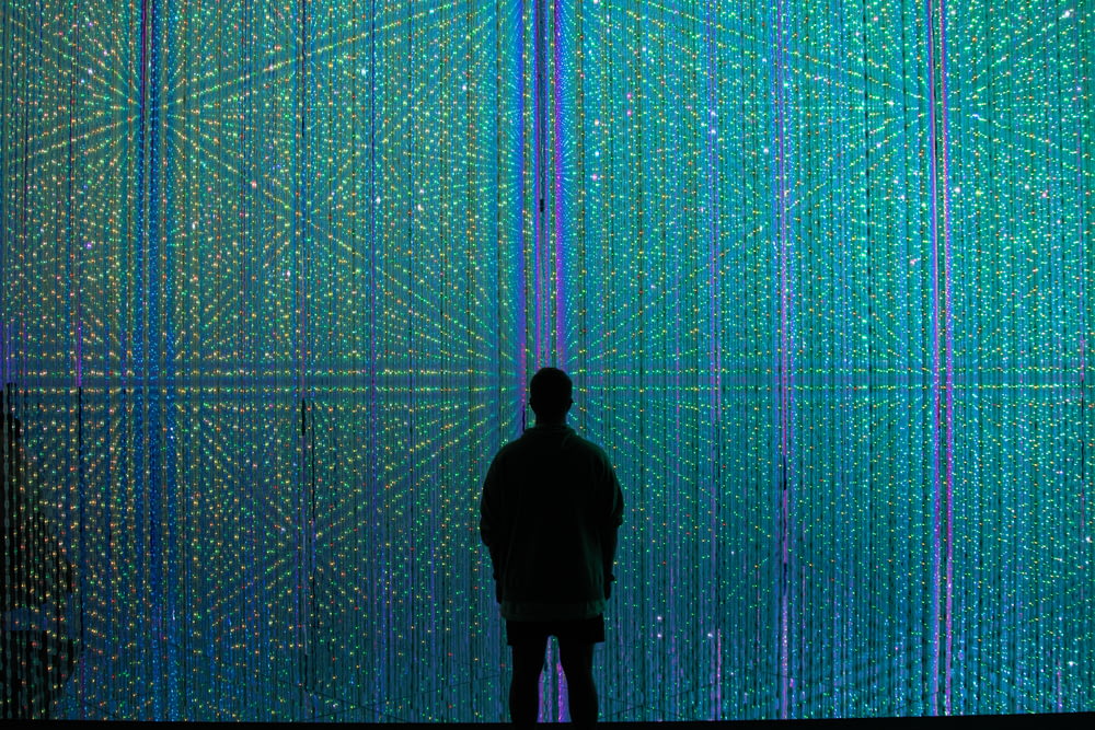 a person standing in front of a wall of lights
