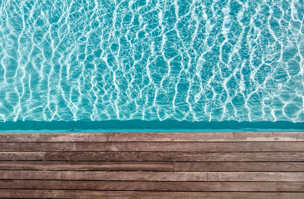 an aerial view of a pool with a wooden deck