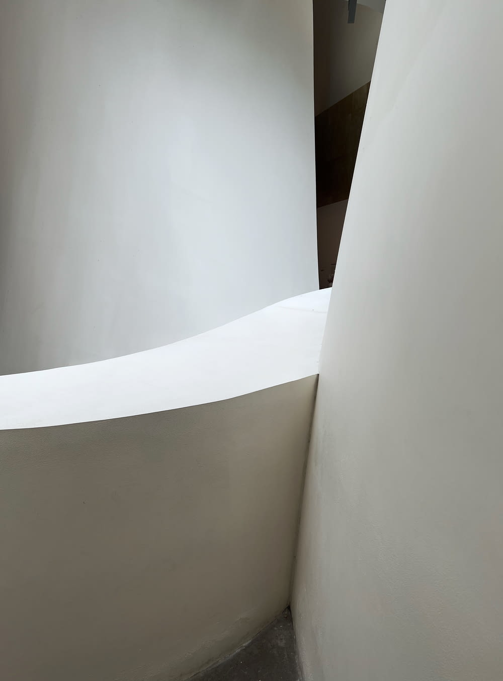 a curved white wall in a corner of a room