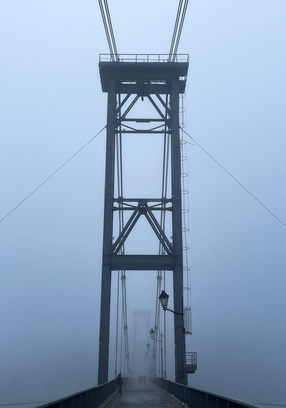 a foggy bridge with a street light on it