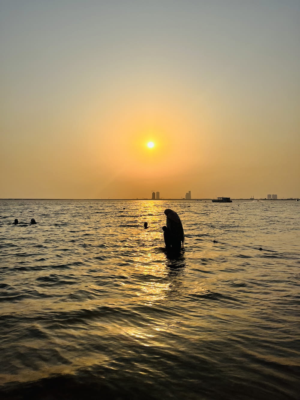 a person standing in the water at sunset