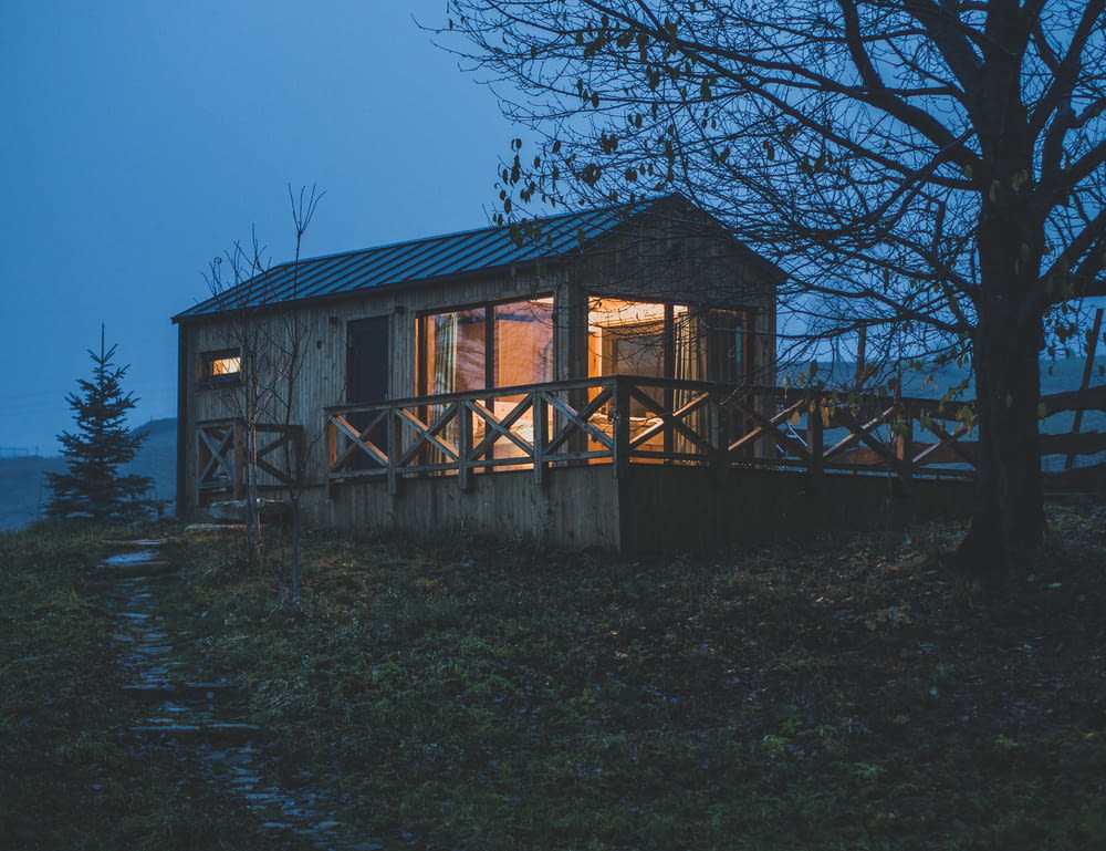 a small cabin sits on a hill at night