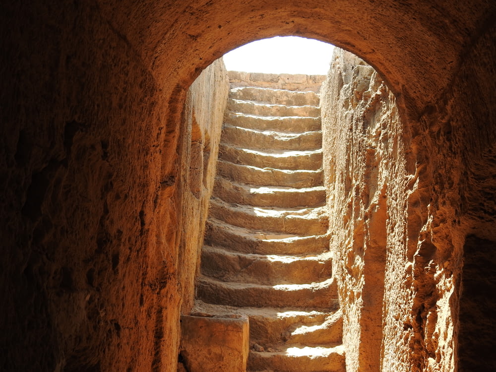 uma escada de pedra que leva a uma luz brilhante no fim de um túnel