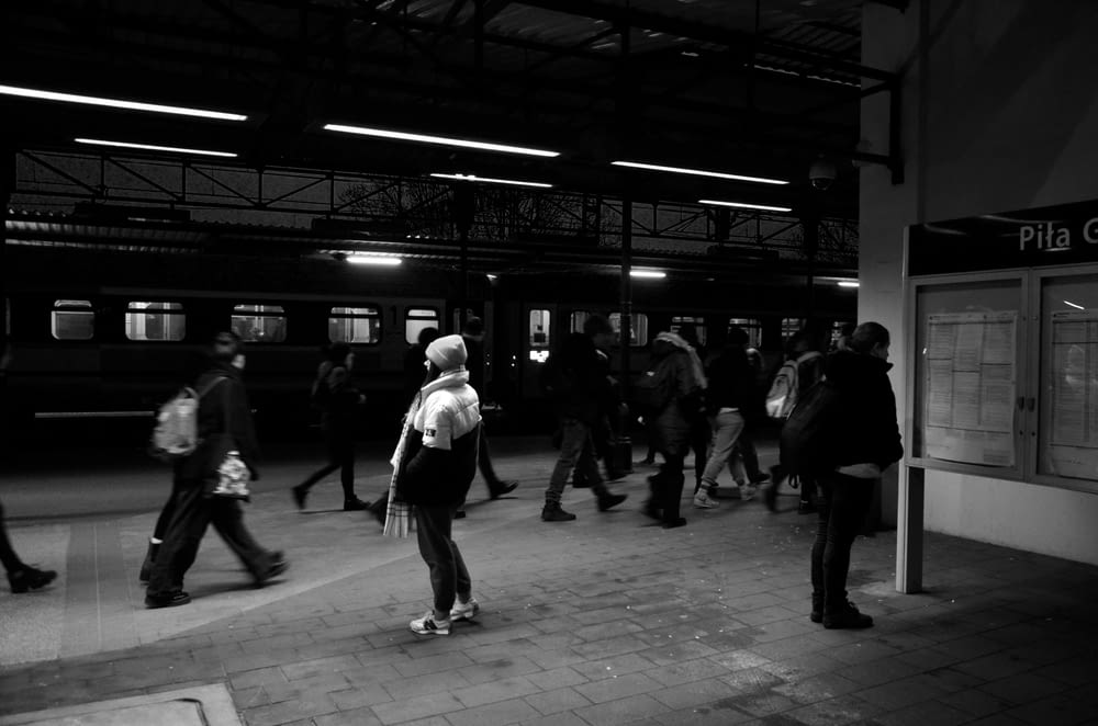 a group of people walking around a train station