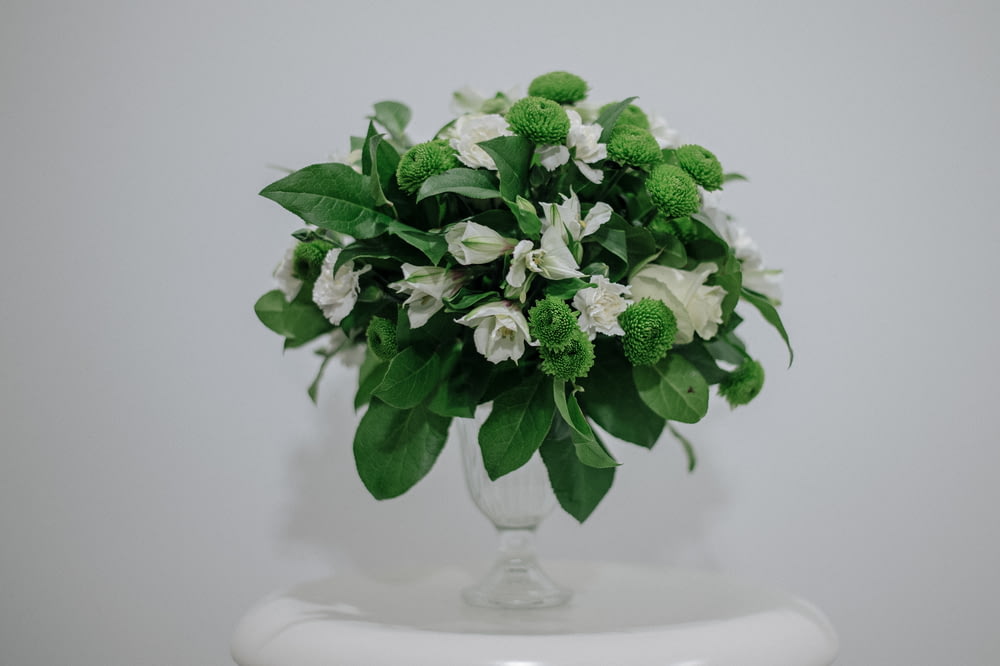 a vase filled with white and green flowers