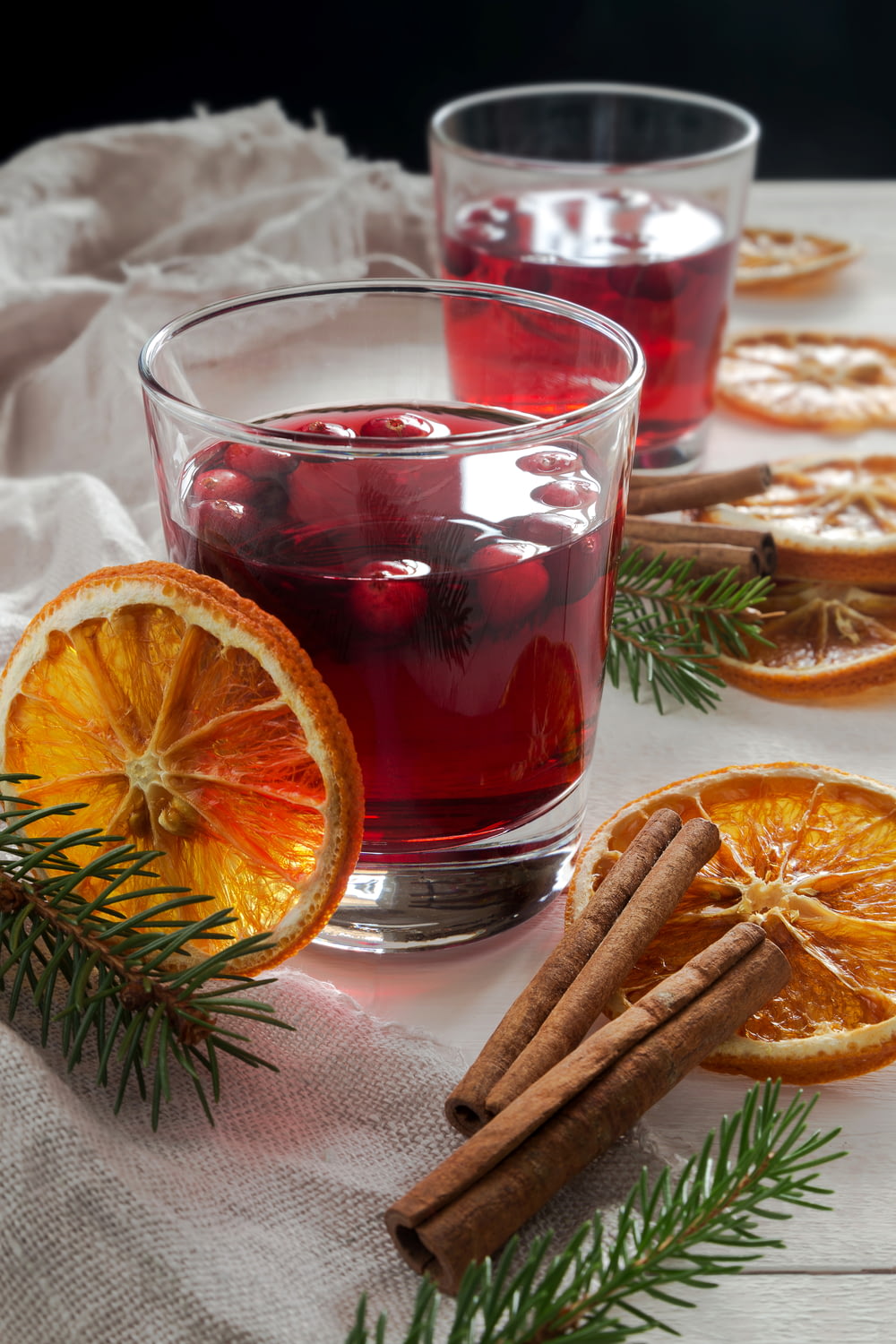 two glasses of mulled with cinnamon and orange slices