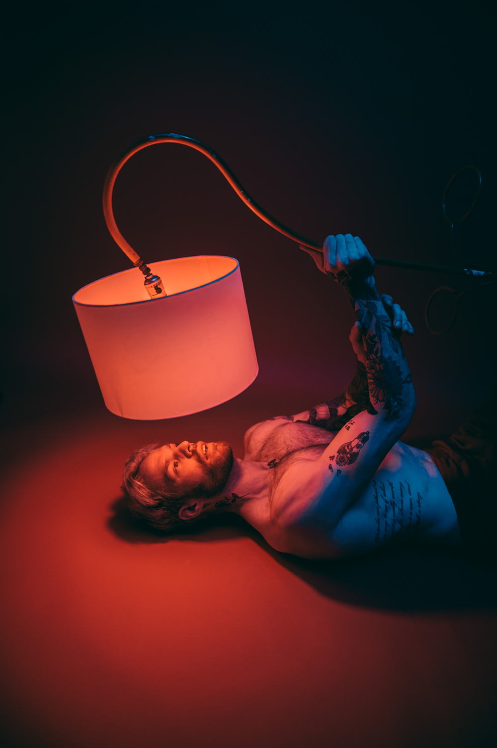 a woman laying on the ground next to a lamp