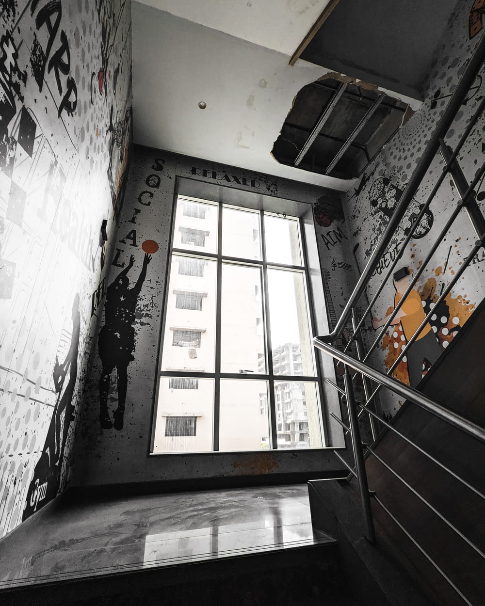 a stairwell with graffiti on the walls and a window