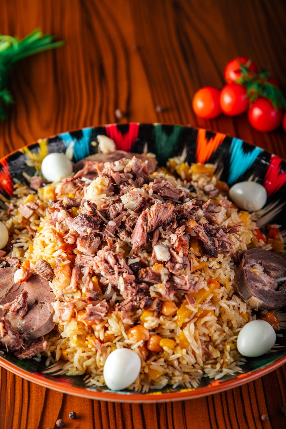 a plate of food with meat, rice and tomatoes