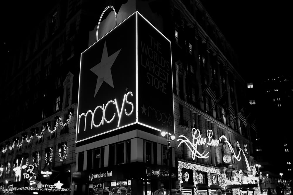a black and white photo of macy's at night