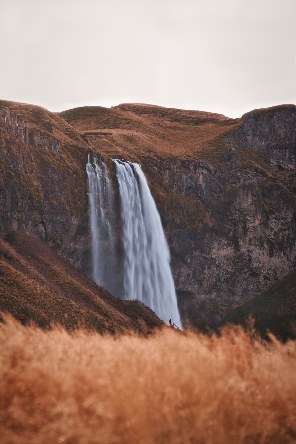 a tall waterfall in the middle of a field