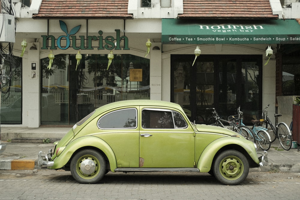 a green car parked in front of a building