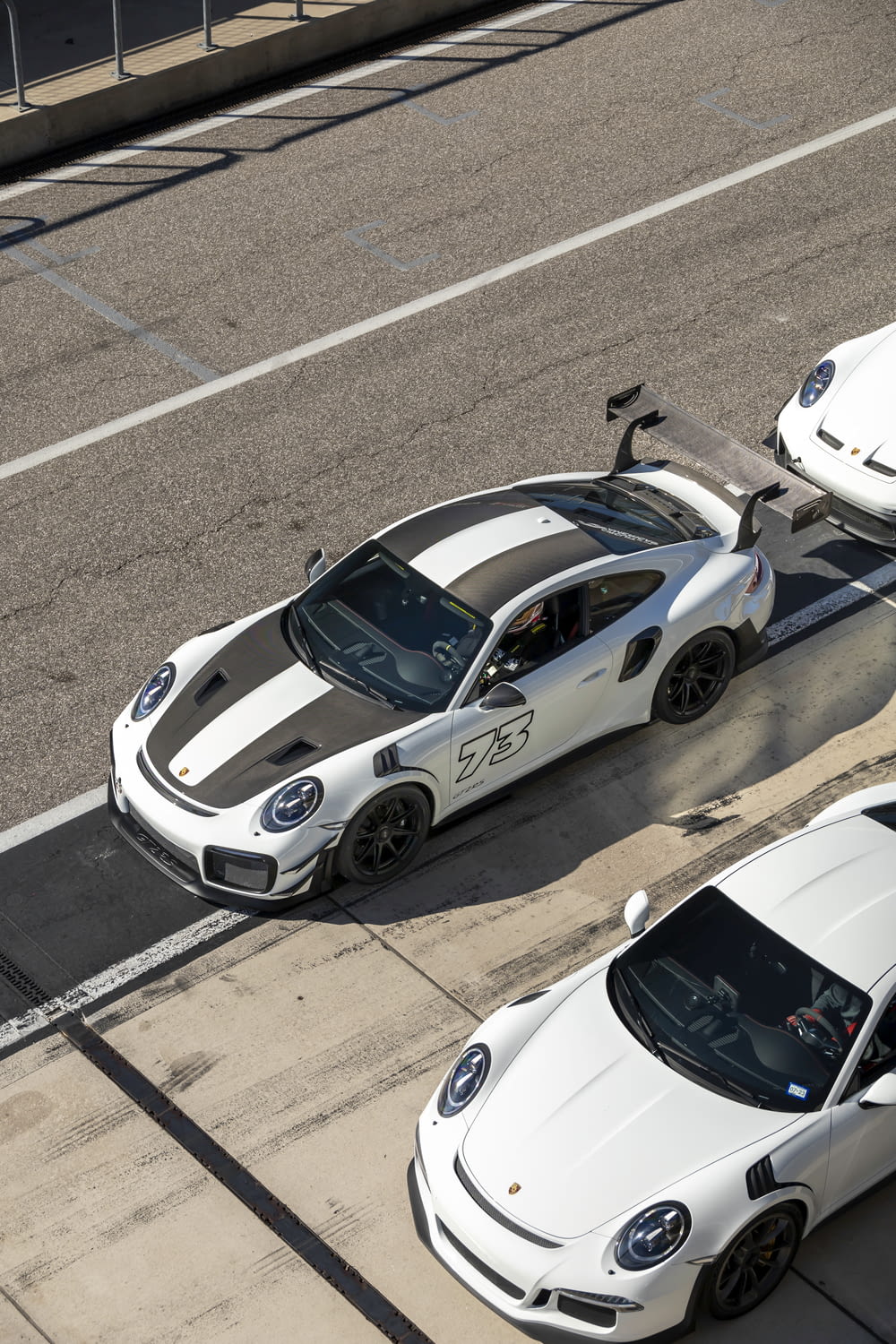 two white sports cars parked next to each other