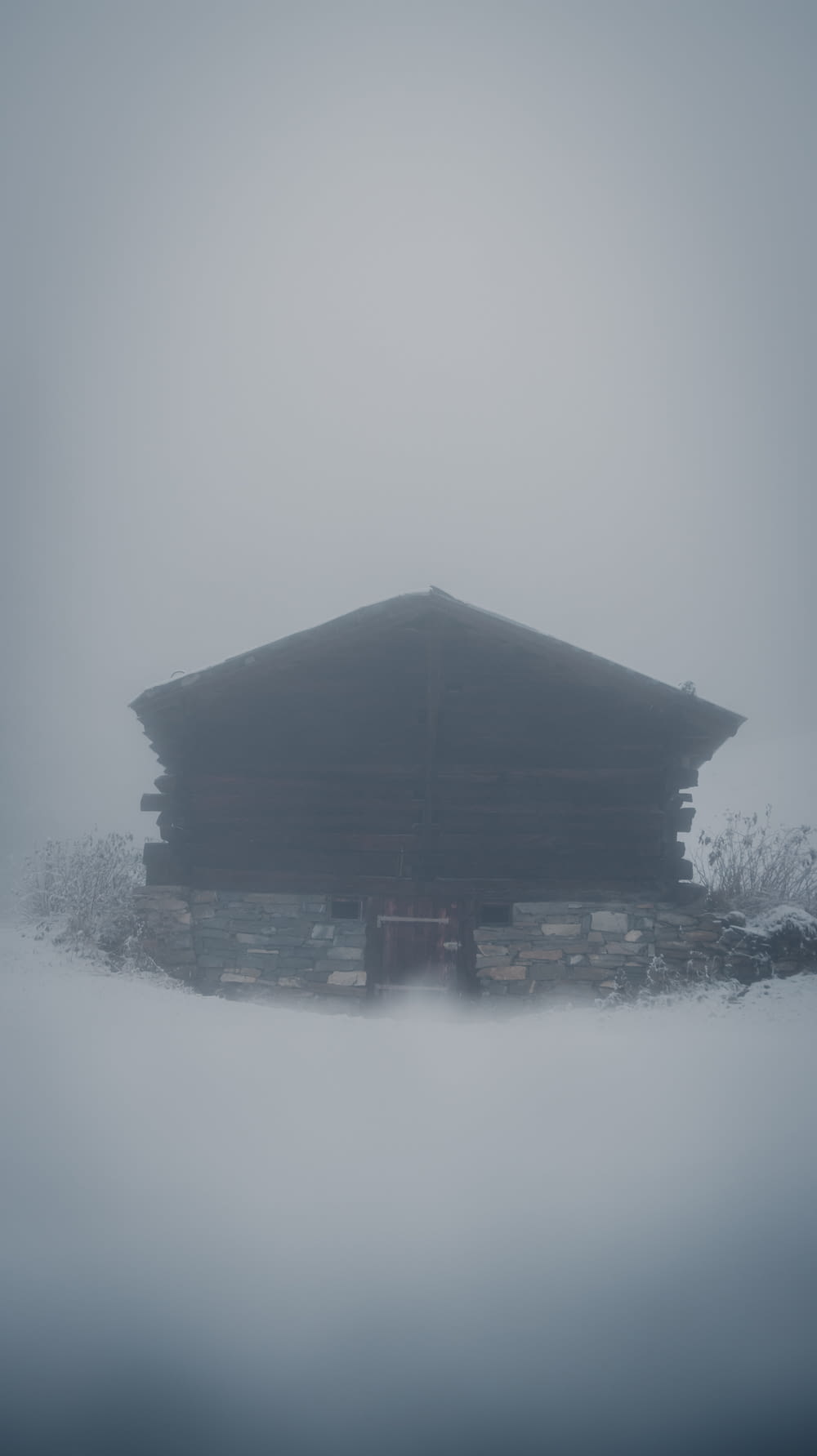 a cabin in the middle of a foggy field