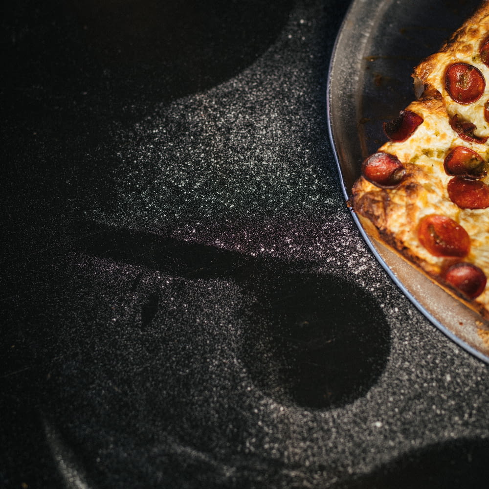 uma pizza sentada em cima de uma panela em cima de um fogão