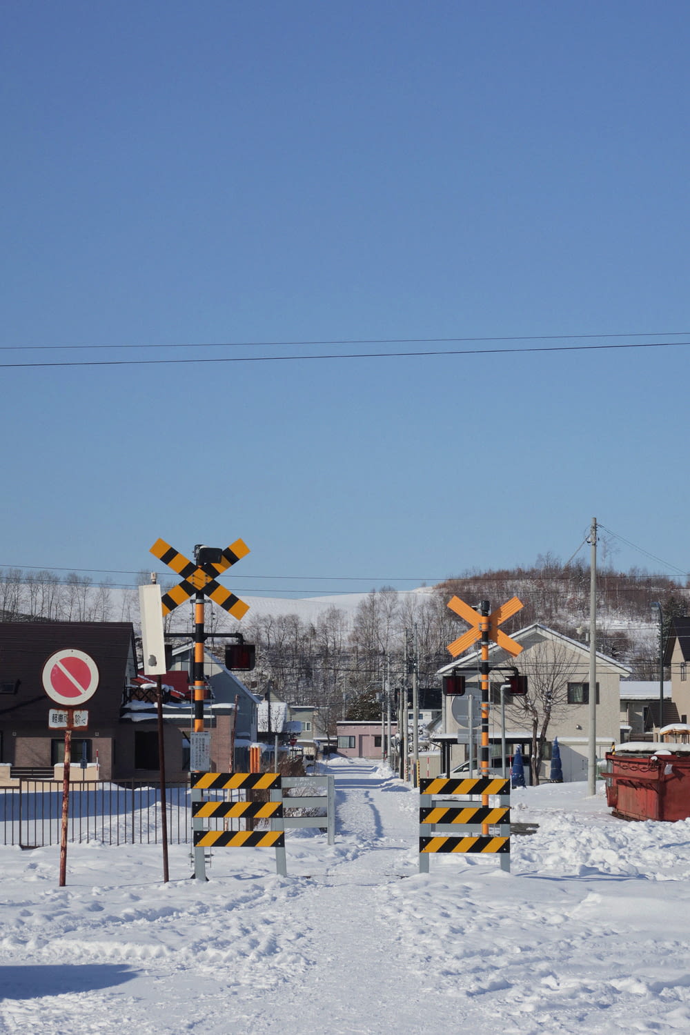 a snow covered field with a railroad crossing sign