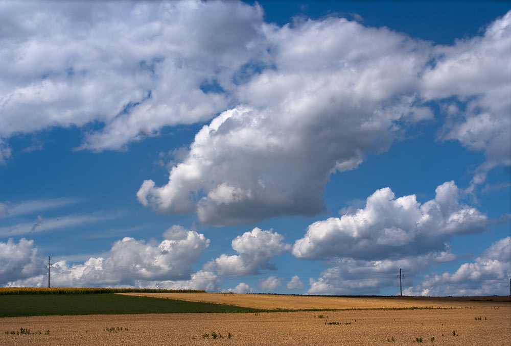 a field with a few clouds in the sky