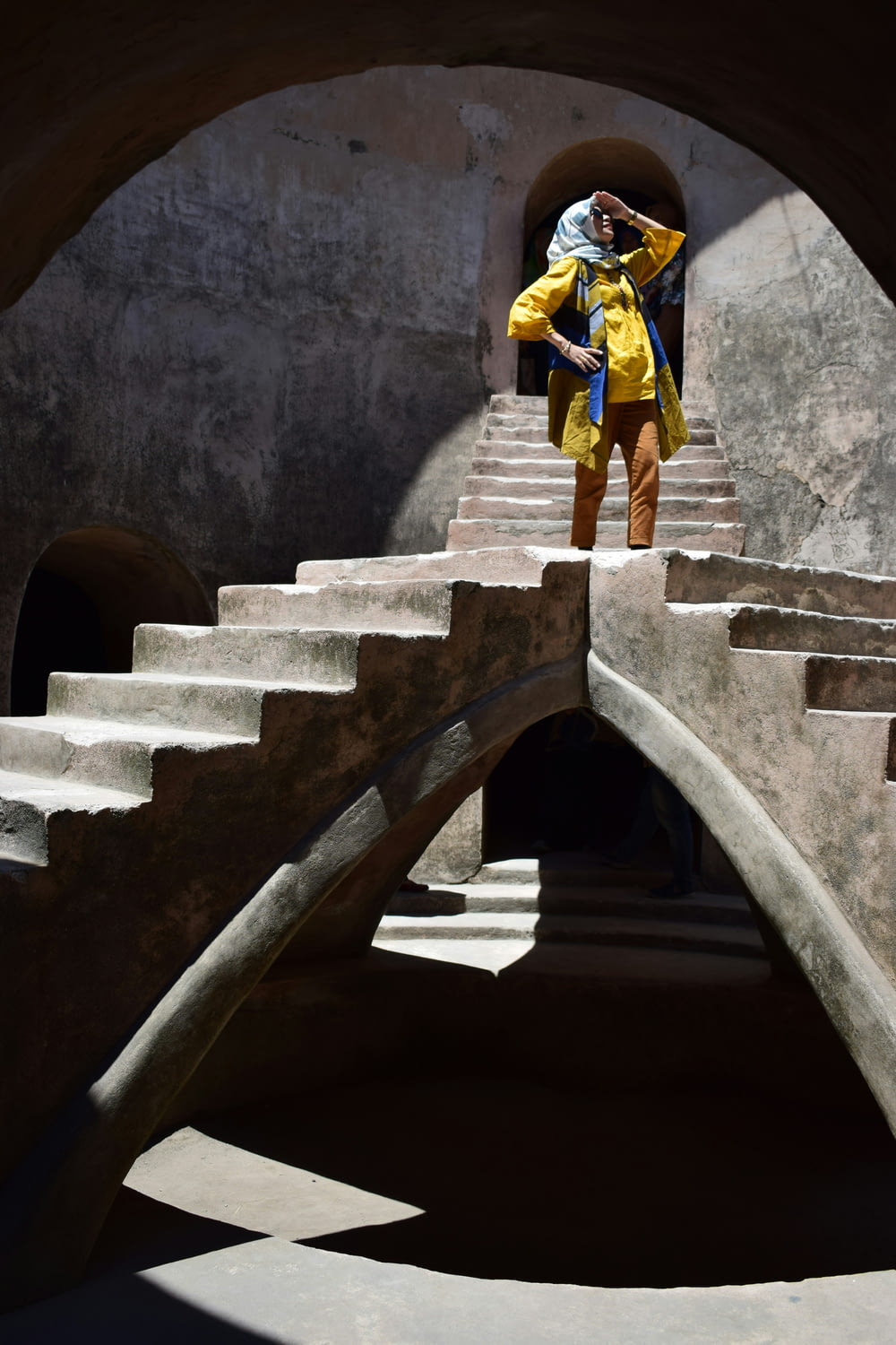 a man in a yellow jacket is standing on a set of stairs