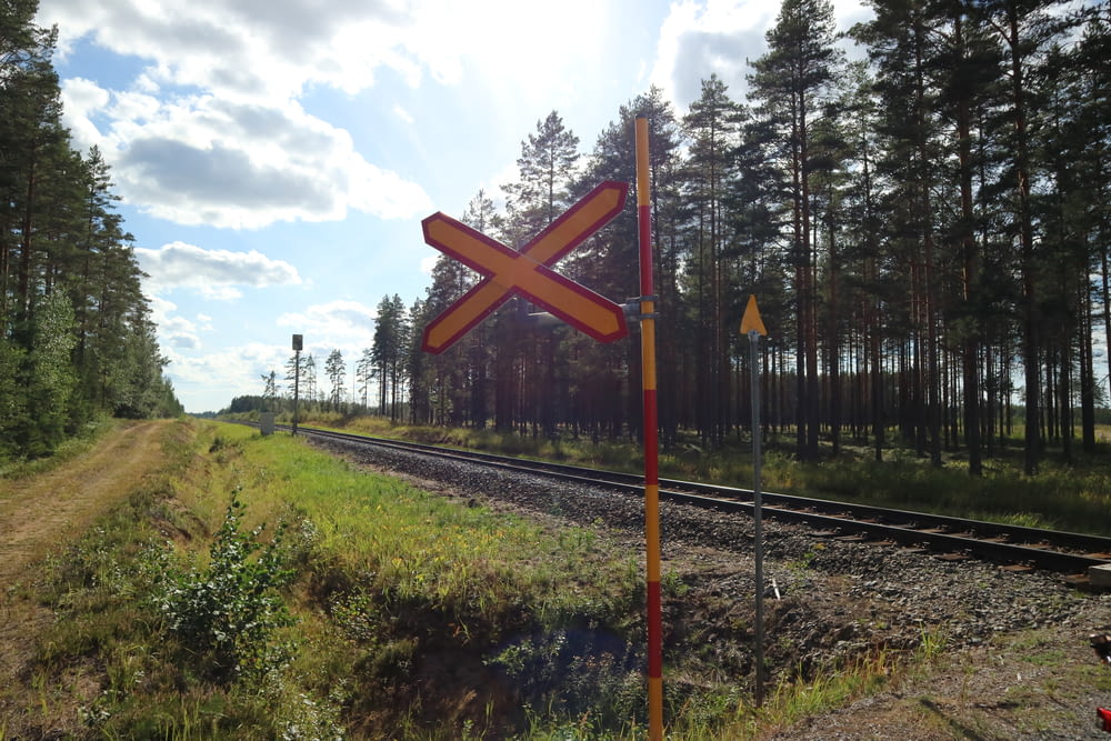 a railroad crossing sign sitting on the side of a train track