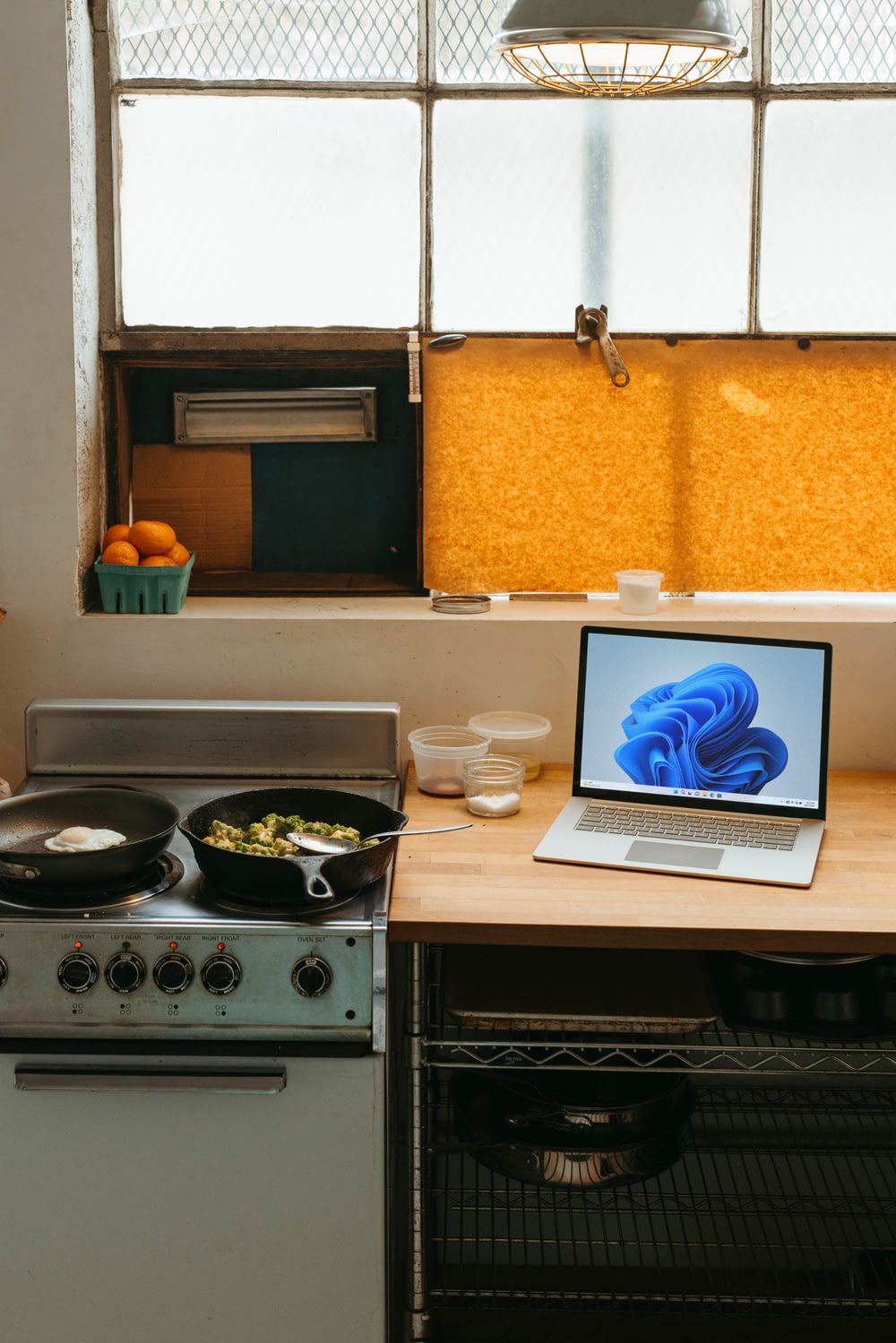 un computer portatile seduto sopra un forno piano cottura