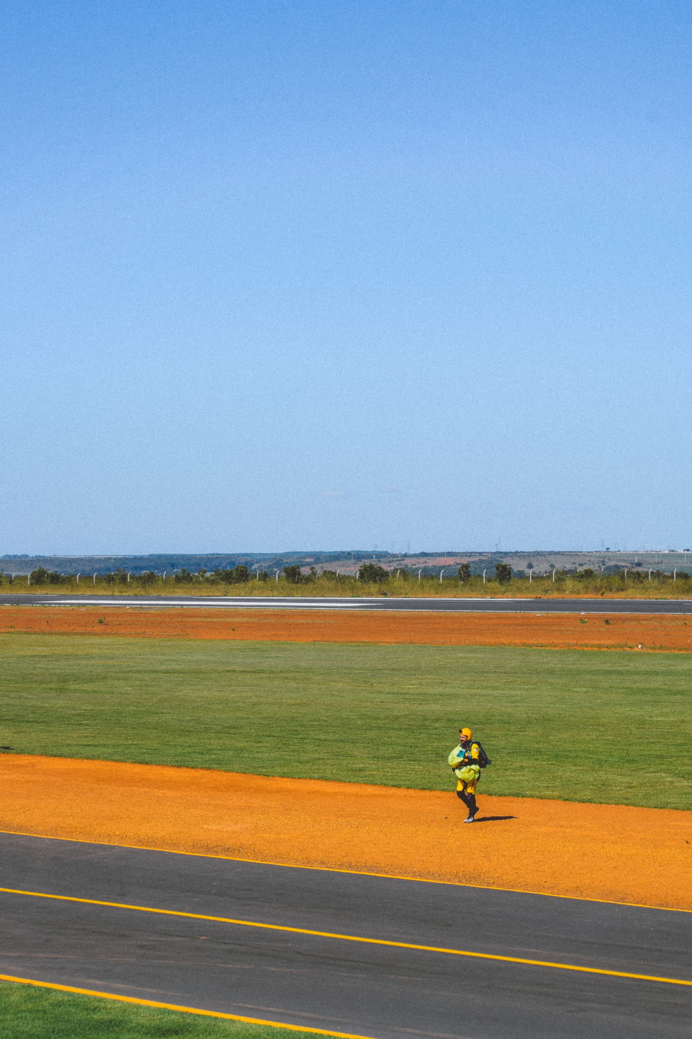 a person running down a road with a kite in the air