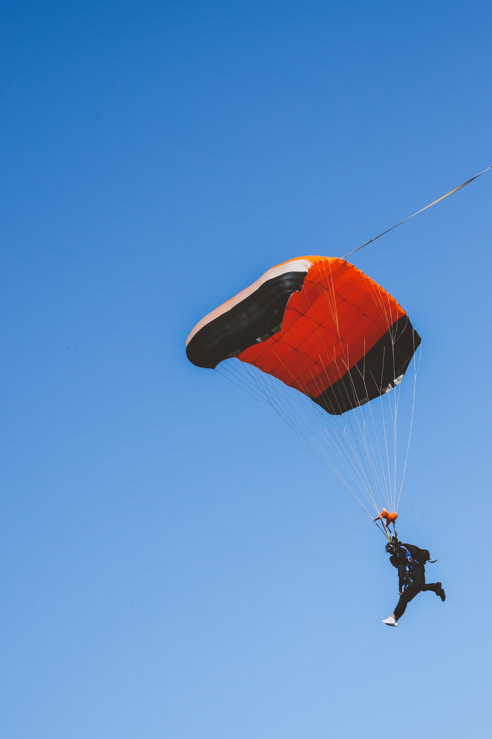 Un uomo che vola in aria mentre si aggrappa a un paracadute